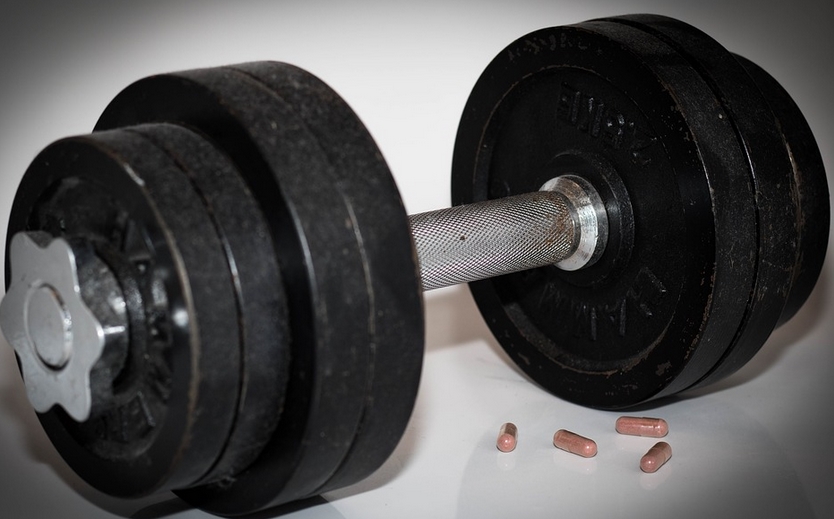 a dumbbell and pills